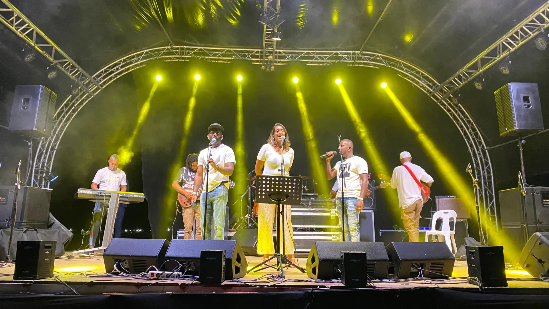 Live band under yellow beam lighting